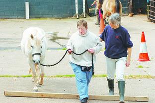 Client Alison Burdett and Julie Milsom take Lucy the pony around an obstacle course.