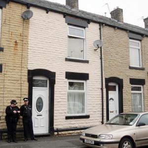 Police officers stand outside the home of five-year-old Sahil Saeed in Oldham.