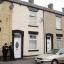 Police officers stand outside the home of five-year-old Sahil Saeed in Oldham.