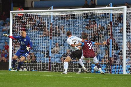 Villa keeper Brad Guzan looks on anxiously as the ball flashes across the goal past Michael Townsend & Chris Herd.