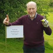 Phil Collins celebrates hitting a hole in one at the 15th hole