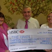 Merry Millers Ian Pugh (Centre) and Janey Cotton (left) present their £13,111 cheque to Haven community fundraiser Lesley Leach