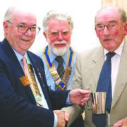 District governor Dave Fenwick presents Cyril Jones (right) with a golf trophy. Centre is City of Hereford club president, Ron Giles.