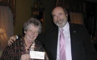 Ledbury Rotary Club’s president Una Morgan receives donation from Rotarian Andrew Perry.