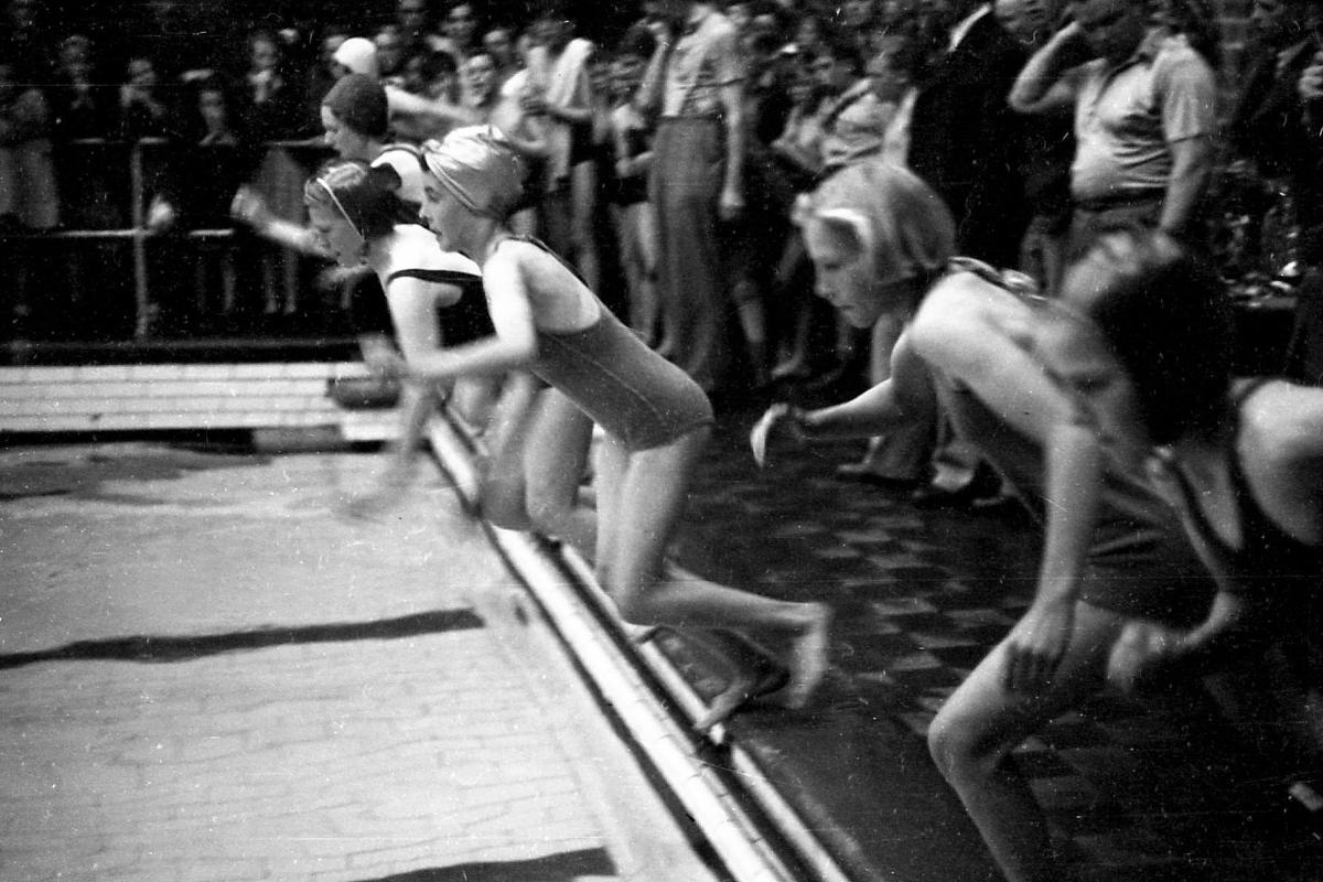Swimming gala at Hereford Baths on Edgar Street. November 3rd 1945.  Girls jumping in at the start of a race.