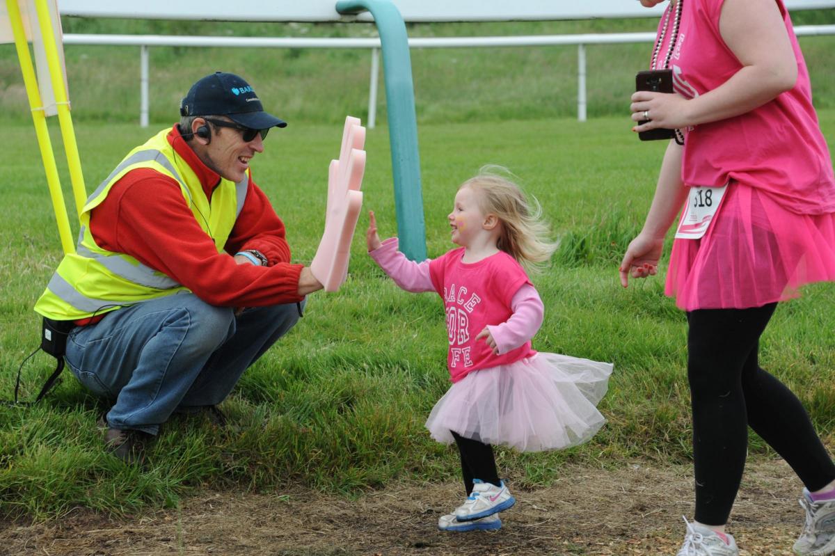 Young runner Sophie Taylor gives race marshall Neal Bright a high-five.  1522_6031