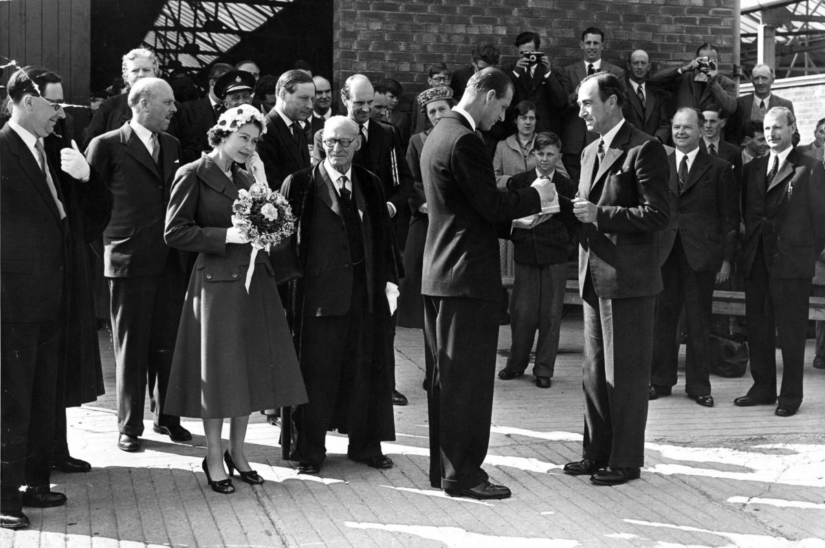 The royal visitor appears to be fiddling with her earrings as Prince Philip receives a traditional cider mug  from Howard Bulmer on a visit to a cider factory.
Photo: Derek Evans Archive at the Herefordshire Archive and Records Centre; Herefordshire Libr