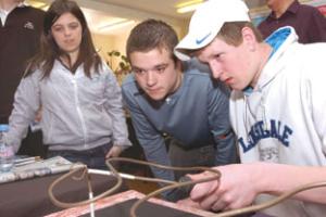 Sam Coe and John Pugh watch Zac Wall have a go at the one-armed challenge. 081421-4.