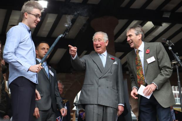 Prince Charles, pictured laughing as a torch goes out during his visit to Ross-on-Wye in 2019, will visit Hay-on-Wye next week. Picture: Steve Niblett