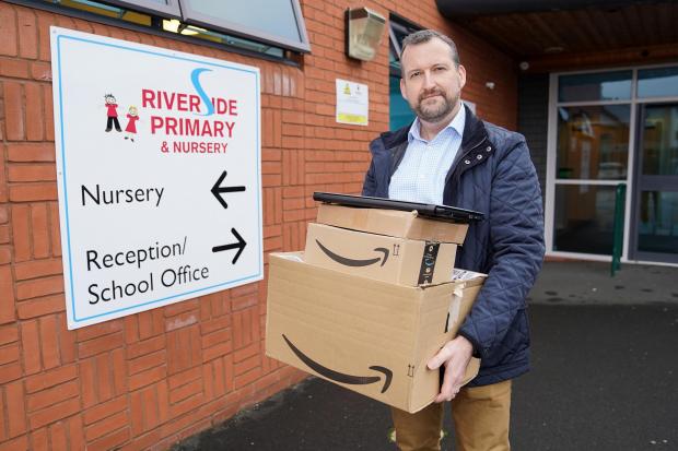 Hereford Times: Tim Brett with laptops which have been donated to children at Riverside Primary School, with other schools across the county also set to benefit. Picture: Rob Davies 