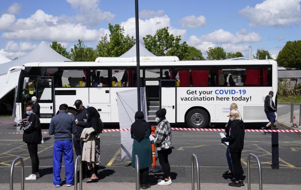 Hereford Times: People lining up at ESSA academy in Bolton for Covid vaccinations as the spread of the Indian variant of coronavirus could lead to the return of local lockdowns.  Image: Danny Lawson / PA Wire 