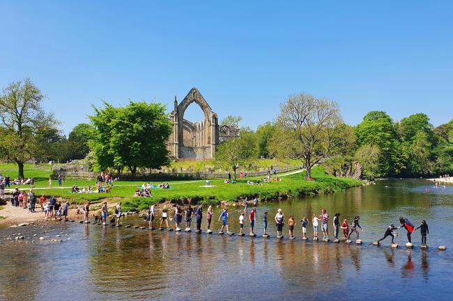 Tackling the stepping stones at Bolton Abbey in North Yorkshire