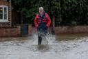 Reg Curtis wading through the floodwater in Eardisland
