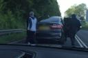 Three men return to the BMW X5 after viciously attacking a white van in a road rage incident off the M5 motorway