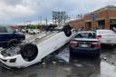 A car is upturned in a parking lot after the severe storm swept through Little Rock (Andrew DeMillo/AP)