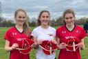 Lacross players Zoë Cripwell, Mille Ryan and Freya Taylor with their caps for representing Wales.