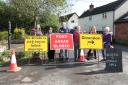 From left: Angie Spencer-Tims, Pam Edwards, Brook Phillips, Geoffrey Crofts, Lisa Sullivan and Anita Syers-Gibson next to the road closure signs