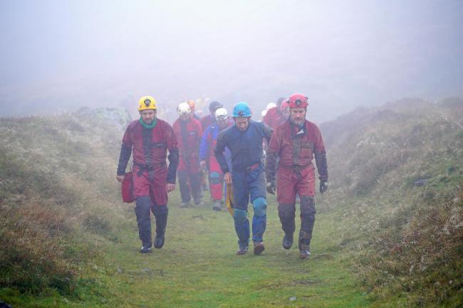Rescuers walk towards the Ogof Ffynnon Ddu cave system near Penwyllt, Powys in the Brecon Beacons, Wales, as rescue mission is underway to save a man. Picture: Ben Birchall/PA Wire