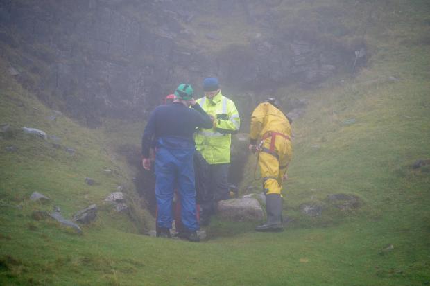 Hereford Times: Rescuers at the entrance of the Ogof Ffynnon Ddu cave system near Penwyllt, Powys where a man has been stuck since Saturday. Picture: Ben Birchall/PA Wire 
