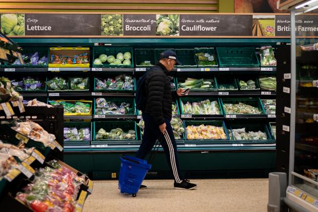 Hereford Times: A shopper walks through the salad aisle in a branch of Tesco (PA)