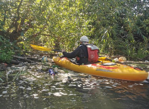 Hereford Times: Sophie Marsh attempting to navigate her way through rubbish and branches as she heads downstream on the Lugg