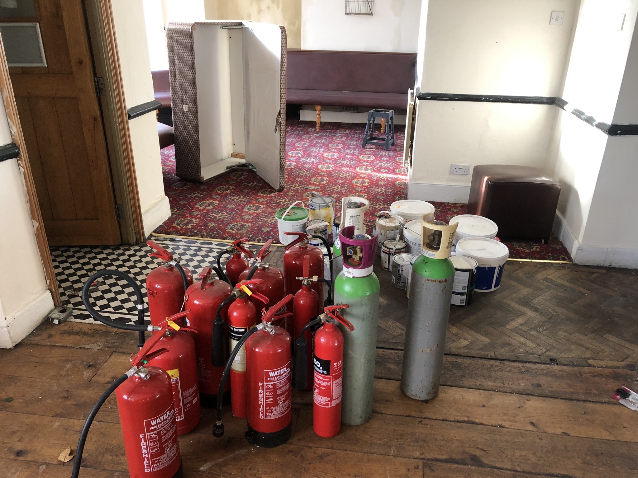 A pile of fire extinguishers in the main room of the ground floor