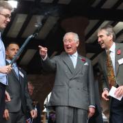 Prince Charles, pictured laughing as a torch goes out during his visit to Ross-on-Wye in 2019, will visit Hay-on-Wye next week. Picture: Steve Niblett