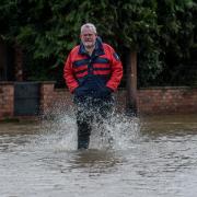 Reg Curtis wading through the floodwater in Eardisland