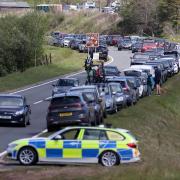 A police car monitors traffic as members of the public flock to Pen-y-Fan in the Brecon Beacons, with the Pont ar Daf car park seen in the background