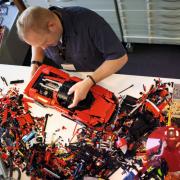 A man assembling LEGO's new Technic Ferrari Daytona SP3. Credit: LEGO