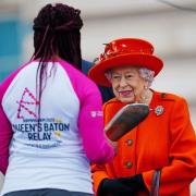 The Queen passes her baton to the baton bearer, British parasport athlete Kadeena Cox, during the launch of the Queen's Baton Relay for Birmingham 2022. Picture: Victoria Jones/WPA Pool/Getty Images