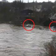 Cars are stuck in a flooded car park in Hay-on-Wye