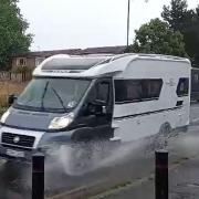 A camper van drives through a puddle on the Straight Mile in Hereford