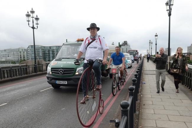 Alan Price cycles across Battersea Bridge
